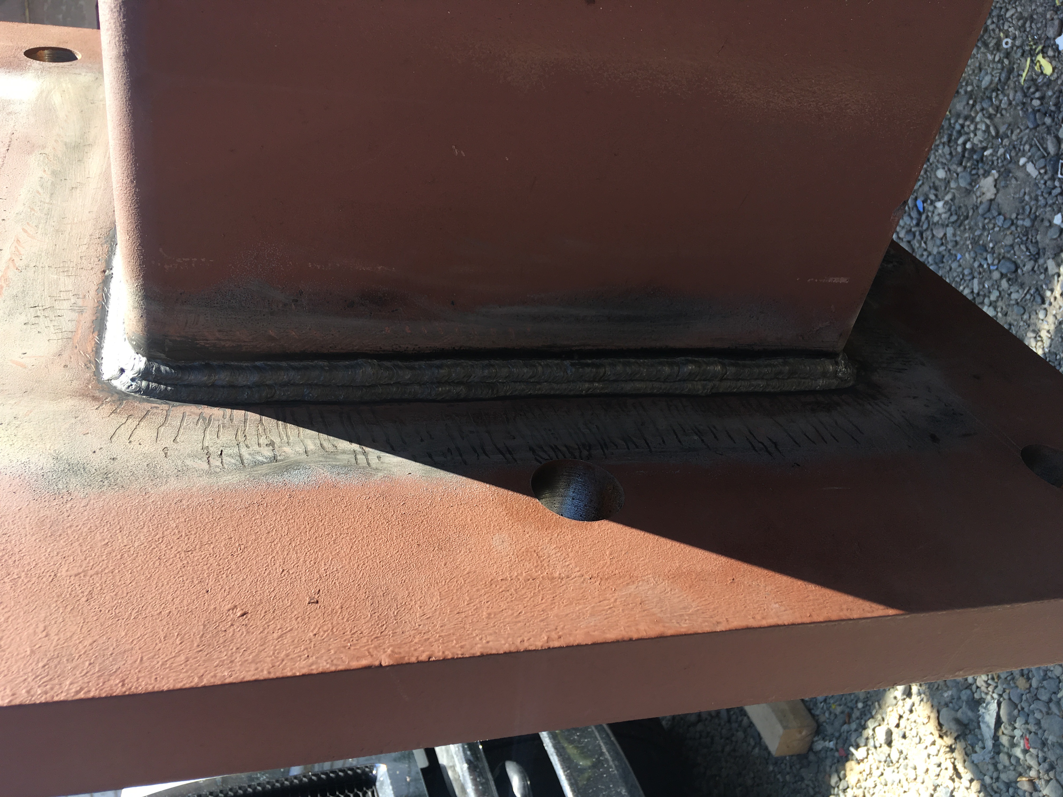 Rusted metal panels joined with welded seam on textured surface